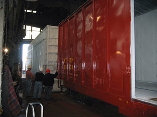 WTRM 8009 high cube box car before remanufacturing — workers inspecting car in shop